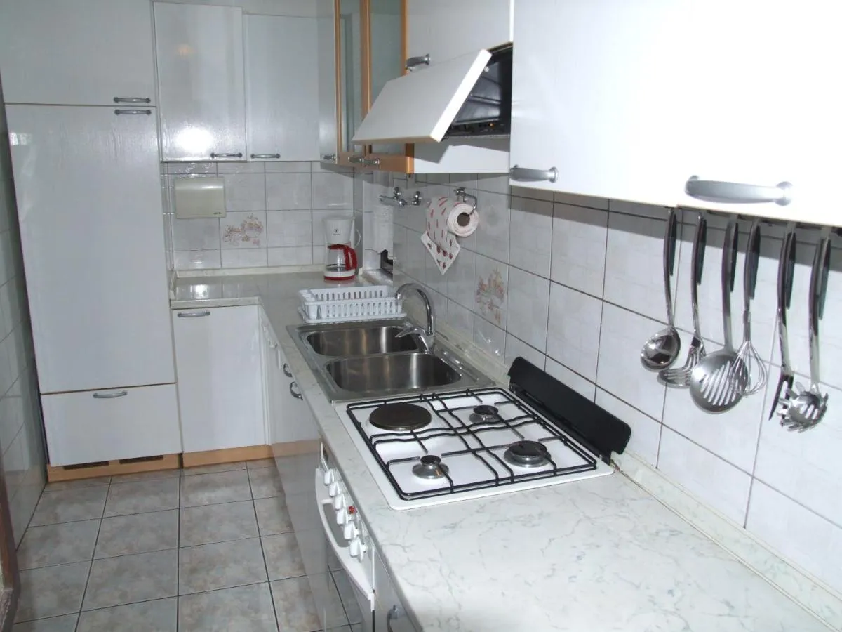 Bela kuhinja s štedilnikom in hladilnikom
